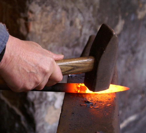 knife being hammered into shape in a forge