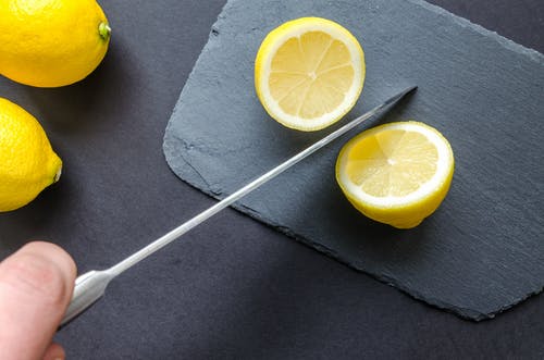 Image showing the spine of a knife that is cutting through lemons